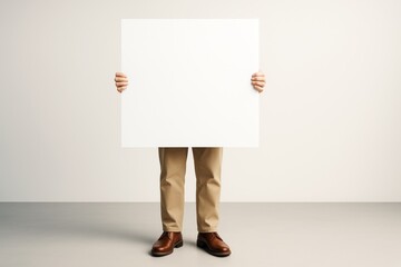 Poster - Man holding blank white square poster with hidden face on light background, ideal for business mockup, branding, or promotion concept template.