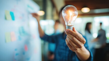 Poster - Person holding a light bulb as a representation of innovative ideas and concepts in a clean minimalistic style