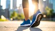 © Sumi - Low-angle close-up of runner's feet in blue athletic shoes on city path, sunlit