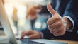 © Kinza - Person gives thumbs-up while using laptop. Success concept for marketing, web design, editorial, or business.