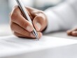 © CollyWang - A hand writes on paper with a pen.