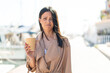 © luismolinero - Young woman at outdoors holding a take away coffee at outdoors with sad expression