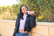© luismolinero - Young woman  holding a bowl of fruit at outdoors