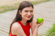 © luismolinero - Young pretty woman at outdoors with an apple and with a bottle of water