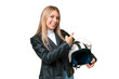 © luismolinero - Young pretty blonde woman with a motorcycle helmet over isolated chroma key background pointing back