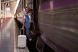 © Pichsakul - Older Asian Woman Travels Train Station Platform Suitcase Journey