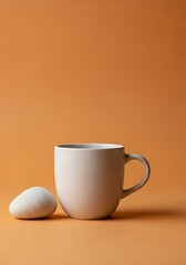 Poster - Minimalist ceramic mug and stone composition on warm orange background for creative concepts