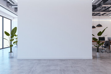 Poster - Blank white wall in modern open office interior with concrete floor, plants, and workspace desks with computers in background. 3D Rendering