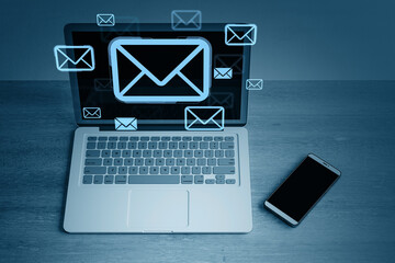 Poster - Digital email communication concept with envelope icons displayed on laptop screen and floating around smartphone on wooden desk background. 3D Rendering