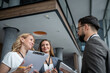 © Migma_Agency - Businesspeople discussing work in modern office building lobby