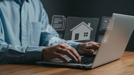 Man typing on laptop with house and document icons floating above the keyboard on a wooden desk top