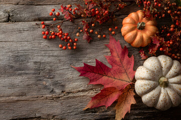 Poster - Top view of Autumn maple leaves with Pumpkin and red berries on old wooden background. Thanksgiving day concept.