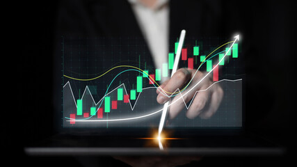 Poster - A close-up view of a hand interacting with a digital stock market graph, displaying trading data and trends. This image captures modern financial analysis and technology integration. Impute