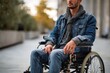 © Iftikhar alam - Man in wheelchair dressed in casual attire sitting outdoors in an urban environment during a sunny afternoon