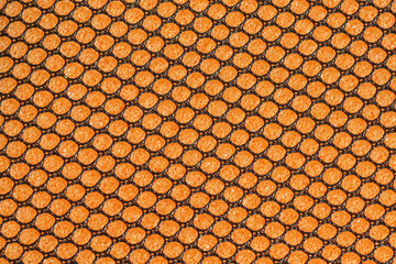 Black hex mesh on an orange sponge background