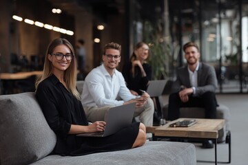 Poster - Young business professionals collaborating in a modern office setting with laptops and engaging discussions in a dynamic workspace atmosphere
