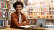 © Home-stock - Portrait of African American smart student guy sitting at desk in university library, looking and smiling at camera