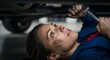 © Photo Moon - Young Asian woman mechanic lying under car holding wrench tool working in automotive garage repair shop