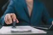© Nirusmee - Businessman validates and manages business documents and agreements, signing a business contract approval of contract documents confirmation or warranty certificate, approval stamp