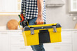 © New Africa - Professional repairman with tool box indoors, closeup