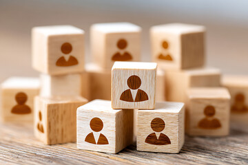 Poster - Wooden Blocks With Human Figures Representing Teamwork and Collaboration on a Wooden Surface