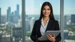 © Nashihal - Portrait of young Hispanic professional business woman standing in office. Happy female company executive, smiling businesswoman entrepreneur corporate leader manager looking at camera using tablet