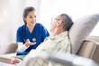 © NAMPIX - Young friendly asian female nurse or caregiver talking to elderly man in nursing home
