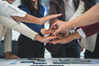 © Crystal - Business people joining hands together over meeting table after successful agreement showing teamwork, unity, cooperation, collaboration and support in business partnership