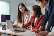 © Crystal - Three young asian businesspeople are discussing work while analyzing financial data on a laptop computer in the office, showing teamwork and collaboration