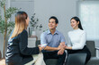 © Crystal - Young asian couple holding hands and smiling listening to female financial advisor explaining investment strategy during consultation meeting in office