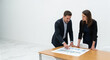© Hasan - Two business professionals collaborate intensely over financial charts and graphs during a meeting in a modern .