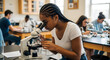 © Veggymulyanto - Focused student using a microscope in a high school science classroom, surrounded by classmates.