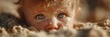 © Michael - Baby with sparkling blue eyes playing in sand on a sunny beach during summer afternoon