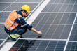 © Hip.hub - Worker inspects solar panels on a rooftop during daytime at a construction site