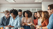 © ipolstock - Diverse group of happy young adult colleagues enjoying a relaxed coffee and lunch break together in a modern office kitchen. Socializing and laughing in a friendly, multiethnic team environment.