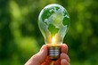 © taponart - Hand holding glowing light bulb with green Earth map inside, concept of eco energy, sustainable innovation, global environment protection, clean energy, and green technology