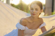 © SHOTPRIME STUDIO - Young woman in a white dress enjoying a sunny day, lying in a hammock, with soft light creating a dreamy atmosphere, perfect for relaxation and tranquility