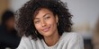 © Jane_S - Smiling young african female in cozy sweater with curly hair and gold hoop earrings
