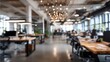 © Subin - A blurred view of a modern office space showcasing desks, lighting, and plants in a vibrant, collaborative environment.