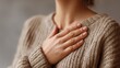© XiZhuo - Person gently patting chest with hand, expressing empathy and care, close-up gesture, soft neutral background