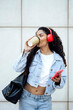 © VISTA by Westend61 - Businesswoman listening to music on headphones with coffee in city