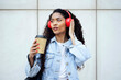 © VISTA by Westend61 - Student with coffee and red headphones listening to music in urban setting
