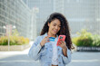 © VISTA by Westend61 - Woman holding credit card and smartphone outdoors in city