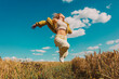 © VISTA by Westend61 - Stylish woman with blonde hair jumping in wheat field under blue sky