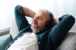 © Prostock-studio - Joyful senior man reclining on couch with closed eyes, listening to music, using powerful wireless modern headphones, closeup, copy space. Modern technologies and entertainment concept