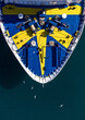 © AmazingAerialAgency - Aerial view of a ferry with a bold blue and yellow design slices through the dark water, creating a striking contrast of color, Split, Split-Dalmatia County, Croatia.