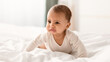 © Prostock-studio - Portrait of crying African American infant in bodysuit whining, crawling on white bedsheets in bedroom at home indoors. Closeup of irritated baby feeling upset, banner, blurred background