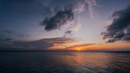 Wall Mural - evening sunset sky, dramatic golden hour dark blue cloud, horizon sea sky landscape orange, yellow s