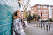 © TrueShot | Westend61 - Cheerful woman laughing while having coffee on footpath