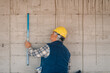 © Ljustina - Construction worker using spirit level on concrete wall at building site